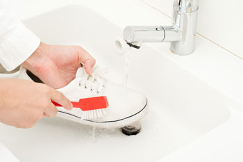 Person Cleaning White Shoes