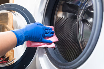 Person Wipes Down Washing Machine