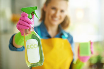 Woman holds up green cleaner