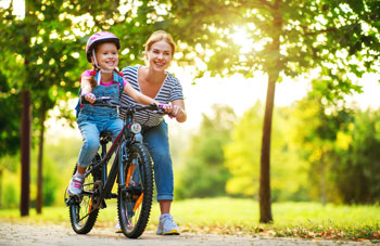 Woman teaches child to ride a bike