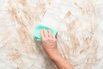 Hand Wiping Dirty Surface with Rag