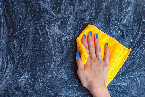 Person Wipes Counter with Microfiber Cloth