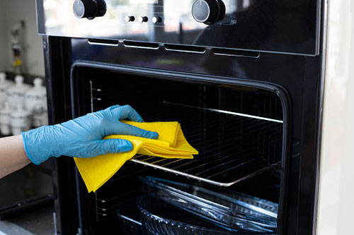 Professional Cleaner Wipes Down Oven